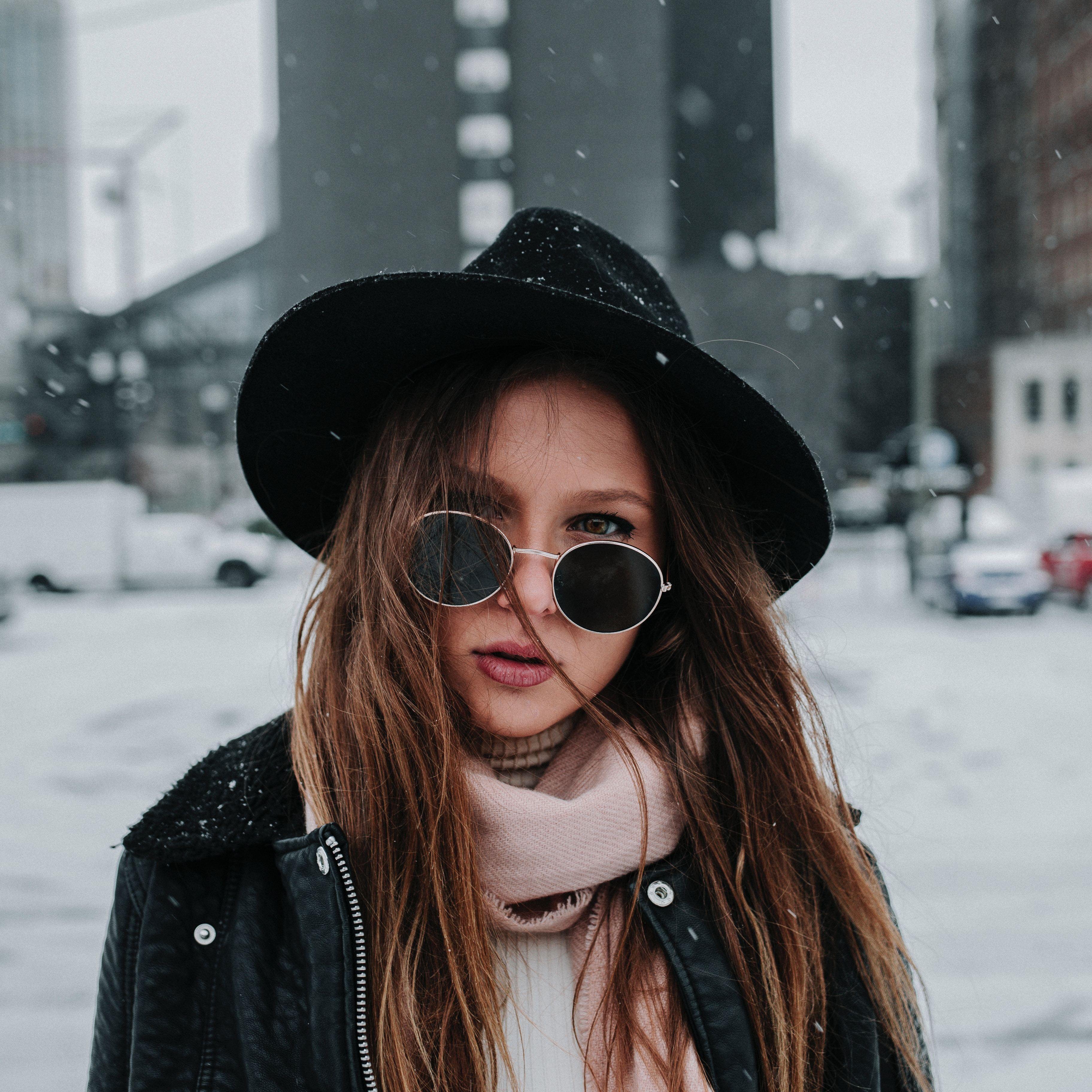 בחורה עם כובע ומשקפי שמש על רקע שלג