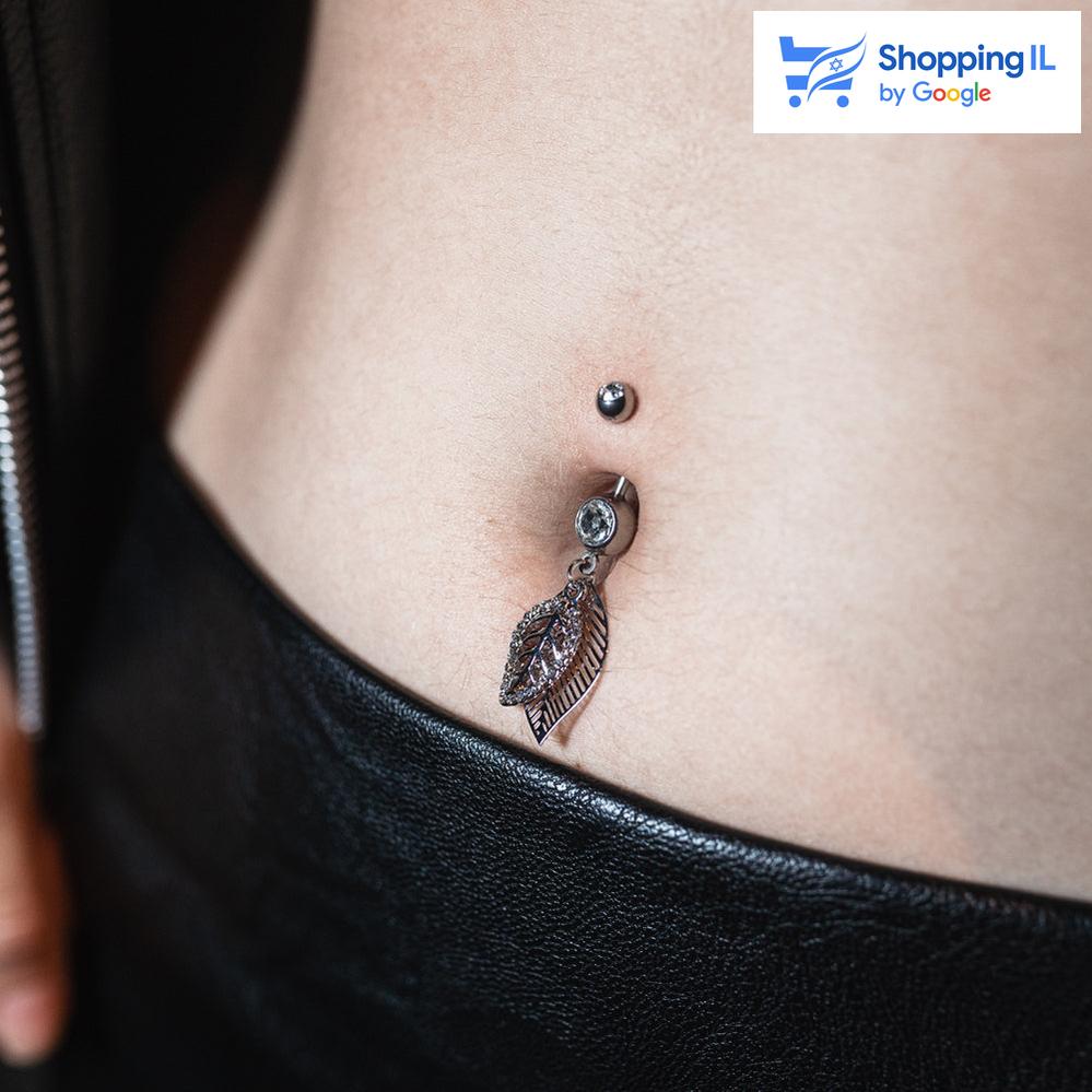 עגיל לטבור ג'ין - עשוי מתכת רפואית. העגיל בעיצוב מוט בננה משובץ זירקונים עם תליון של זוג עלים משובצים זירקונים מקולקציית - הגינה של לאבאס. צבע - כסוף מידה - מגיע בעובי של 1.6 מ"מ ובאורך 10 מ"מ קוטר סוגר - 5 מ"מ  העגיל מיועד בעיקר לאזורים הבאים: - פירסינג בטבור - כמובן שניתן לענוד את העגיל גם באזורים אחרים (: