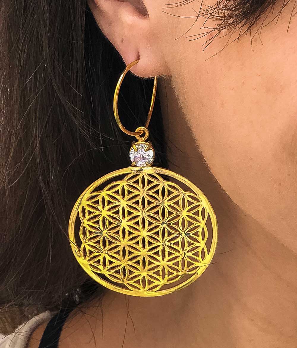 Flower of Life - זוג עגילים תלויים עשויים פליז בציפוי זהב 14K. עגילי ערב בעיצוב לוטוס - פרח החיים משובצים אבן קריסטל נוצצת בקוטר 7 מ"מ. קולקציית עגילי הערב של לאבאס כאן בדיוק בשביל האירועים הנוצצים של החיים! העיצוב, האיכות והייחודיות ברמה הגבוהה ביותר - חשבנו על כל הפרטים בשבילך.  צבע - זהב מידה - מגיע בעובי של 1.2 מ"מ  קוטר הפרח 45 מ"מ העגיל מיועד בעיקר לאזורים הבאים: - עגילים בתנוך האוזן - מתאים כתוספת להרחבה