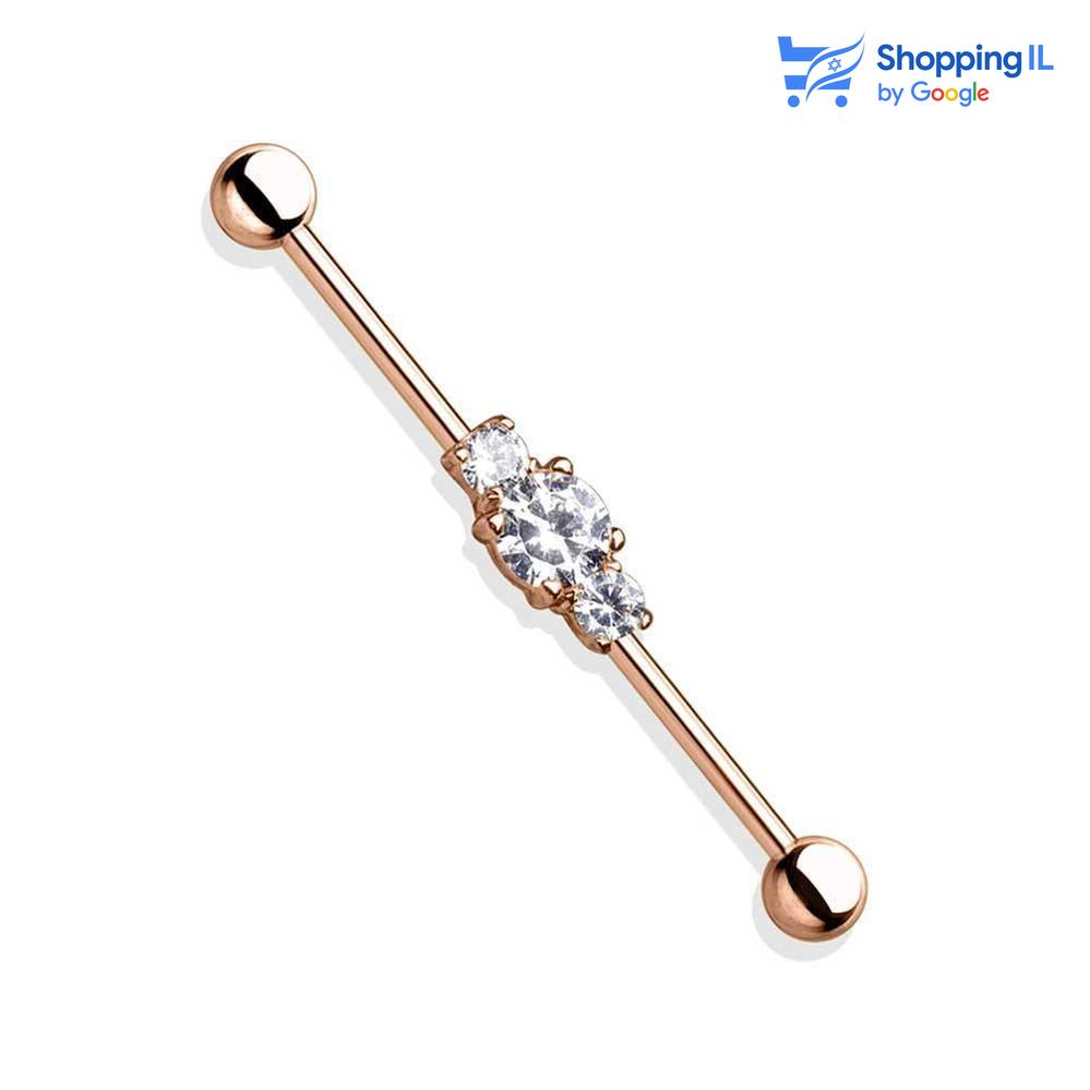 עגיל נועמי מצופה זהב רוז - עשוי מתכת רפואית מצופה זהב רוז. העגיל בעיצוב מוט משובץ שלושה אבני זירקון. צבע - זהב רוז מידה - מגיע בעובי 1.6 מ"מ ובאורך 36 מ"מ קוטר סוגר - 5 מ"מ  העגיל מיועד בעיקר לאזורים הבאים: - פירסינג אינדסטריאל 